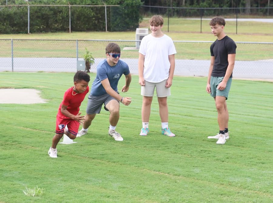 Coach running a speed drill with a young camper
